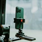 A modern smartphone mounted on a tripod indoors, perfect for tech setups.