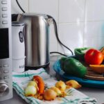A modern home kitchen counter displaying fresh vegetables and appliances, ideal for healthy cooking.